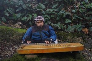 a man playing kecapi traditional Sundanese music in the  Ciwidey, Bandung,west java,  indonesia. photo