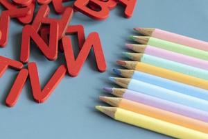 Back to school concept with assorted letters and colored pencils in pastel colors photo