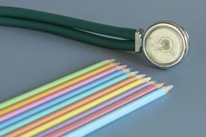 Sample of colored pencils and a stethoscope representing the pediatric doctor photo