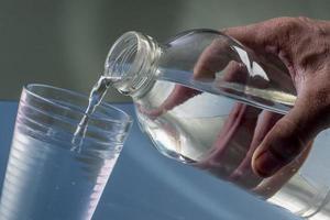 Detail of person filling glass of water. hydration concept photo