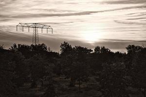 High-voltage power pole with overhead line through which the electricity is transported photo