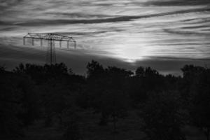 High voltage power pole with overhead line through which electricity is transported photo