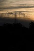 High-voltage power pole with overhead line through which the electricity is transported photo