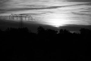 High voltage power pole with overhead line through which electricity is transported photo