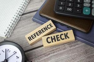 REFERENCE CHECKS symbol. Concept words pay off debts on wooden blocks photo