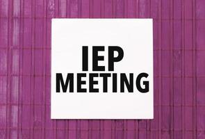 white sticker with text iep meeting on pink wooden background photo