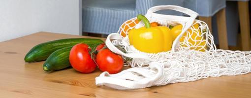 Eco friendly shoppingstring bags on the table with with fresh ripe vegetables. photo