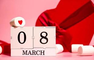 8 march creative card with heart shaped gifts, marshmallows and calendar with 8 march date photo