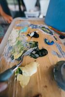 Close up of woman's hand mix paints in palette photo