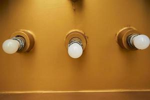 Close up view of white bulbs are installed on golden steel. Surface texture of golden steel for background. photo