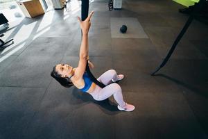 Young woman is climbing a rope in the gym photo