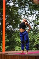 joven mujer atractiva en ropa deportiva estira la mano antes del ejercicio. foto