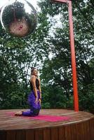 Sporty woman performs kneeling exercises while standing on a mat photo