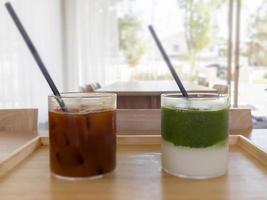Iced americano with orange and iced matcha green tea in coffee shop photo