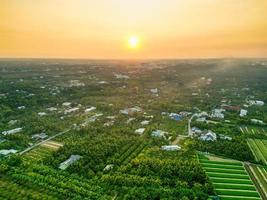 dorado hora magia asombroso puesta de sol terminado tien giang provincia campos con sereno río y paisaje urbano en Vietnam foto