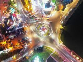 Captivating Timelapse of Nighttime Traffic in Da Lat City, Vietnam A Mesmerizing View of Roundabout, Vehicles and City Lights in Motion photo