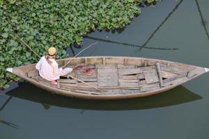 un hombre con pescar barco y captura pescado por hok foto