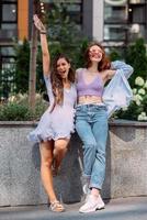 Two young women pose against the background of a building photo