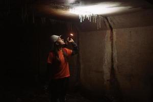 Female digger with flashlight explores the tunnel photo