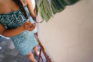 Young woman artist paints with a spatula on the canvas photo