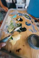 Close up of woman's hand mix paints in palette photo