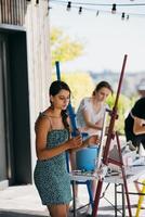 Young woman artist paints with a spatula on the canvas photo