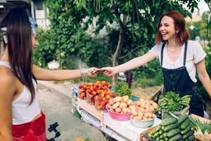 Seller woman offers fresh and organic vegetables farmers market. photo