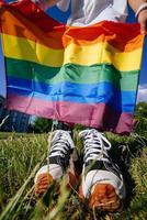 Cropped photo of young woman with LGBT pride flag.