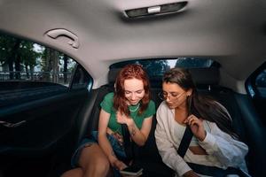 Friends together in the back seat of a taxi photo