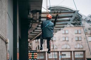 Industrial climber in uniform and helmet rises photo