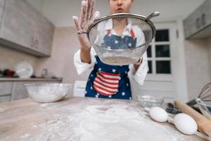 Woman sifting flour through sieve. Selective focus. photo