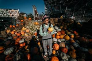 Woman with a small pumpkin among the autumn harvest photo