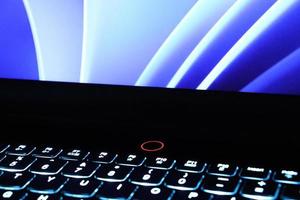 Close up bright monitor and backlit keyboard concept photo. Black keys with illuminated elements. photo