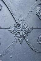 Close up fragment of medieval metal doors with decorative elements. Part of antique old door photo