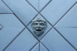 Close up fragment of medieval metal doors with decorative head. photo