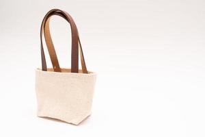 small full canvas bag with ties, Reusable eco bag. Empty small cotton bag with string on white background. photo