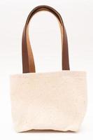 small full canvas bag with ties, Reusable eco bag. Empty small cotton bag with string on white background. photo