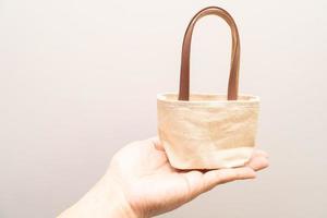 small full canvas bag with ties, Reusable eco bag. Empty small cotton bag with string on white background. photo