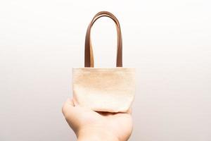 small full canvas bag with ties, Reusable eco bag. Empty small cotton bag with string on white background. photo