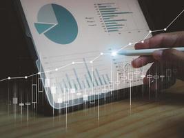 Man's hand pressing on tablet showing graph, income, return on investment. performance with digital technology photo
