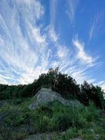 Trees and white clouds by the river with blue water. River landscape. Reflection of the sky in the river. photo