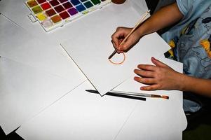 Watercolor paints, on the table. A child draws. photo