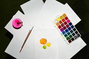 Watercolor paints, on the table. A child draws. photo