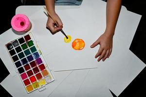 Watercolor paints, on the table. A child draws. photo