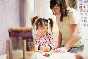 Mother and daughter decorating art with glitter decor. photo
