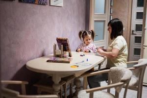 Mother and daughter decorating art with glitter decor. photo