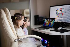 Two girls sisters watching on laptop. Technology and home concept. photo