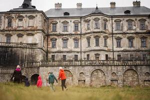 parte posterior de la madre con cuatro hijos visita el castillo de pidhirtsi, región de lviv, ucrania. turista familiar. foto