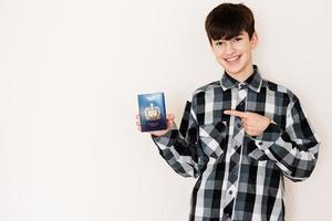 Young teenager boy holding Samoa passport looking positive and happy standing and smiling with a confident smile against white background. photo