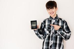 Young teenager boy holding Yemen passport looking positive and happy standing and smiling with a confident smile against white background. photo